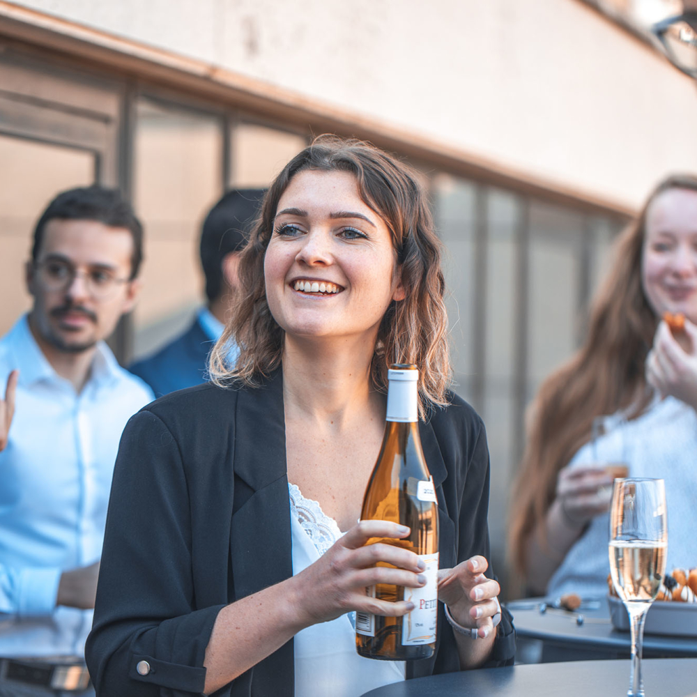 A young woman serves her colleagues during an afterwork