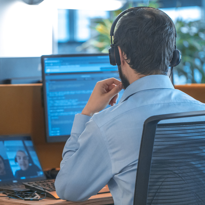 Man looking at several computer screens in night mode