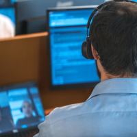 Man looking at several computer screens in night mode