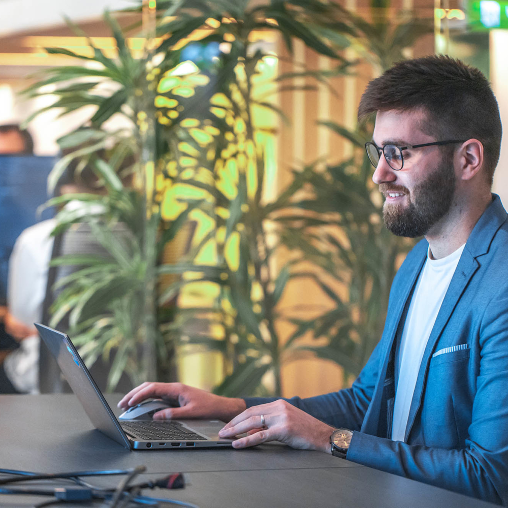 Portrait of young man sitting at his desk in the office