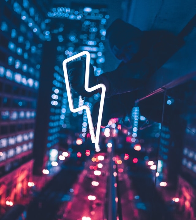 Photo taken at night on top of a building with a neon light