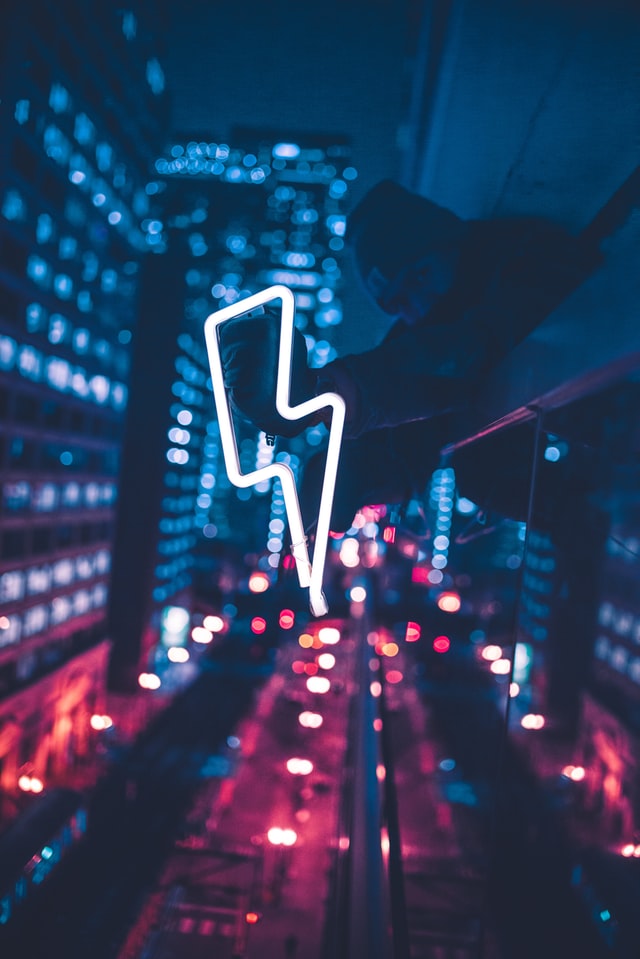 Photo taken at night on top of a building with a neon light